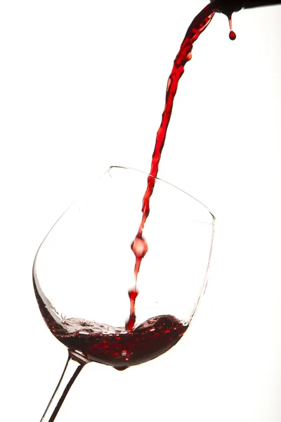 Vin rouge éclaboussé sur un verre, fond blanc . — Photo