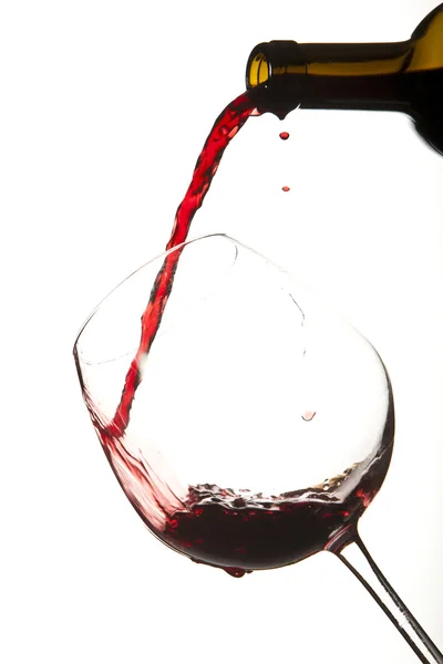 Vin rouge éclaboussé sur un verre, fond blanc . — Photo