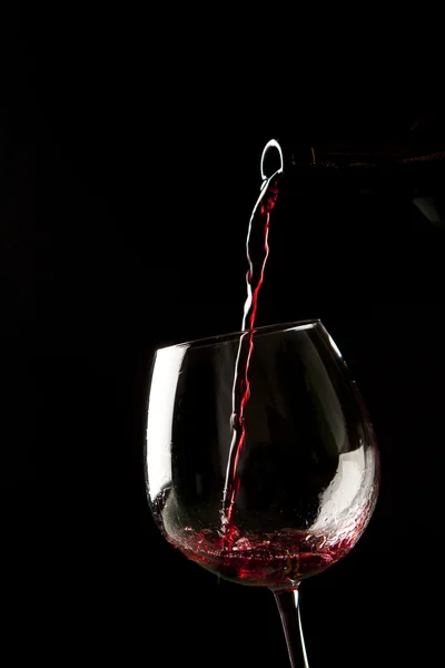 Red wine splash on a glass on black background. — Stock Photo, Image