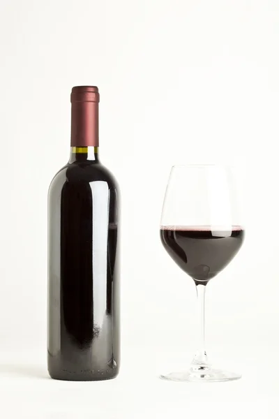 Glas Rotwein und Flasche isoliert über weißem Hintergrund — Stockfoto