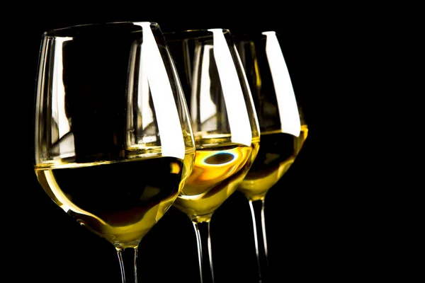 Three glasses of white wine on black background — Stock Photo, Image