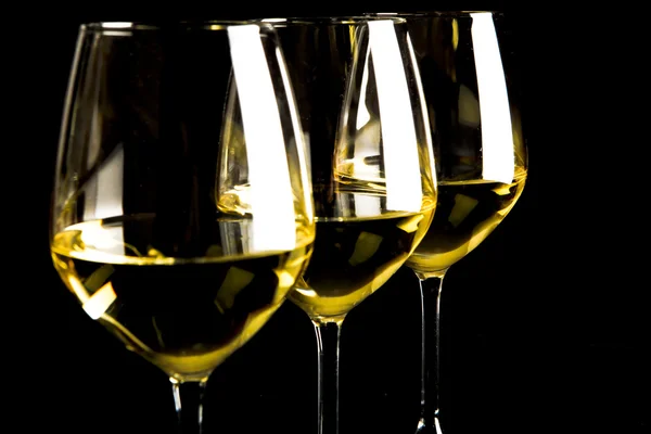 Trois verres de vin blanc sur fond noir — Photo