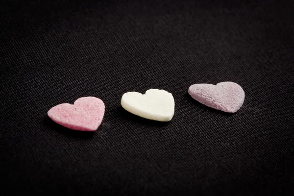 Heart shaped candy sweets on black bakground — Stock Photo, Image