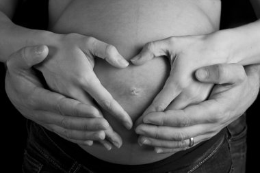 hamile kadın ve kocası onun üzerinde kalp şeklinde olması