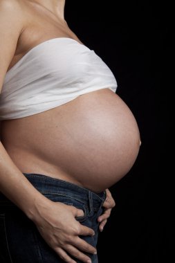 hamile kadının karnında siyah arka plan üzerine