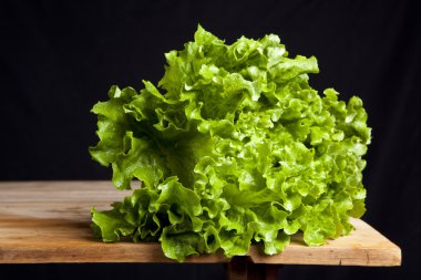 siyah arka plan üzerine ahşap masa üzerinde taze yeşil salata