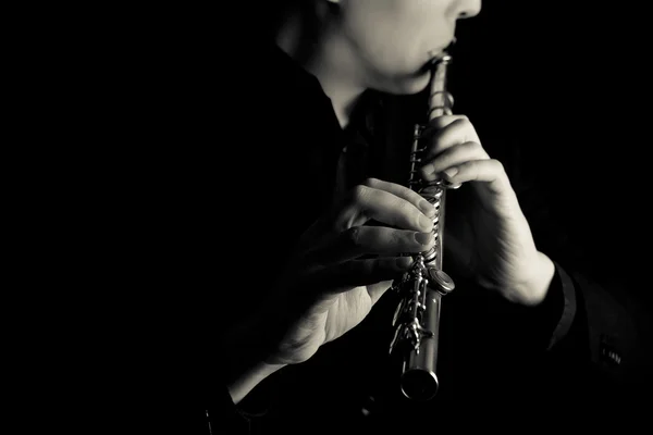 Profesionální flétnista hudebníka, hrajícího na flétnu na černém pozadí — Stock fotografie