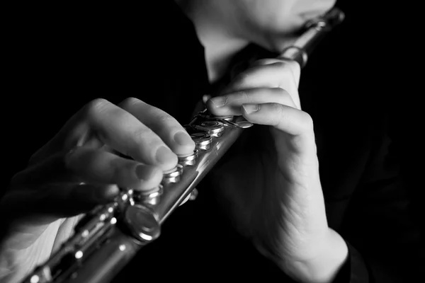 Profesionální flétnista hudebníka, hrajícího na flétnu na černém pozadí — Stock fotografie