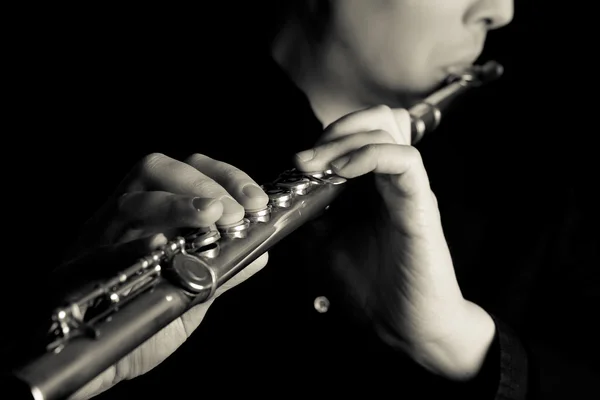 Professional flutist musician playing flute on black background — Stock Photo, Image
