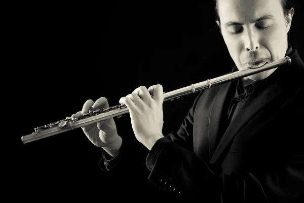 Músico flutista profissional tocando flauta em fundo preto — Fotografia de Stock