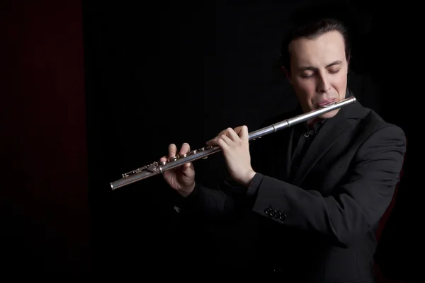 Flecista profesjonalny muzyk gra flecie na czarnym tle — Zdjęcie stockowe