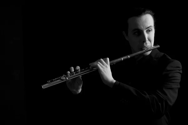 Professional flutist musician playing flute on black background — Stock Photo, Image