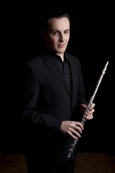 Músico flautista profesional tocando la flauta sobre fondo negro — Foto de Stock