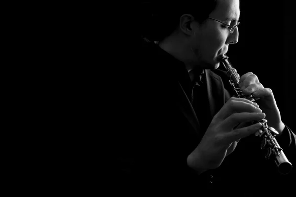 Flûtiste professionnel musicien jouant de la flûte sur fond noir — Photo