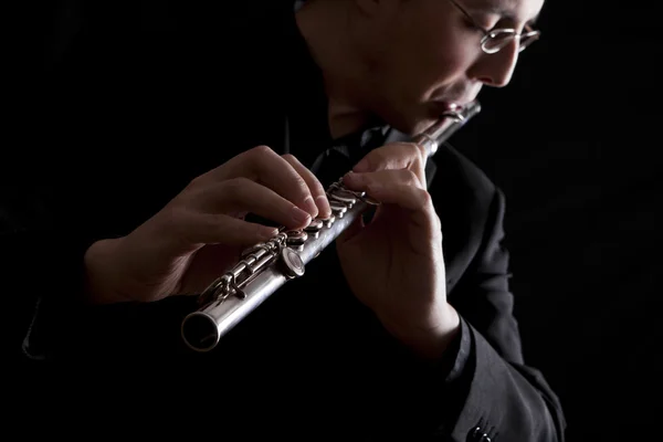 Professional flutist musician playing flute on black background — Stock Photo, Image