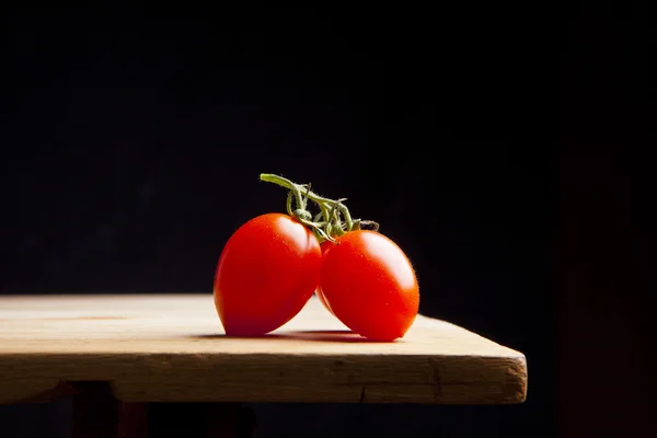 Tomate cereja maduro fresco na mesa de madeira — Fotografia de Stock