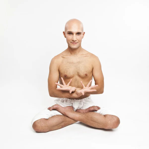 Young man practicing yoga on white background, meditating in lot — Stock Photo, Image