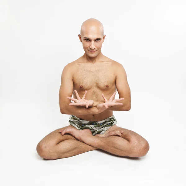 Young man practicing yoga on white background, meditating in lot — Stock Photo, Image