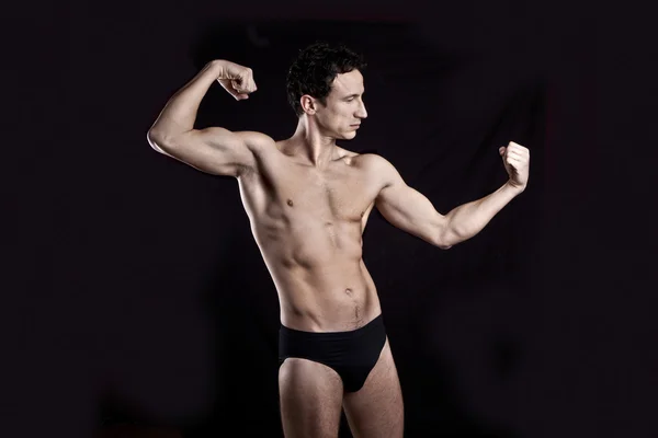 Handsome muscular guy on black background — Stock Photo, Image