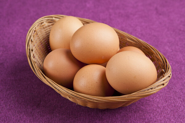 easter eggs in a bascket on purple background