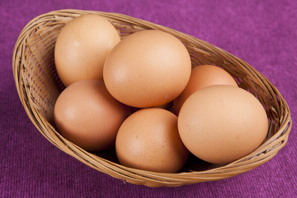 easter eggs in a bascket on purple background