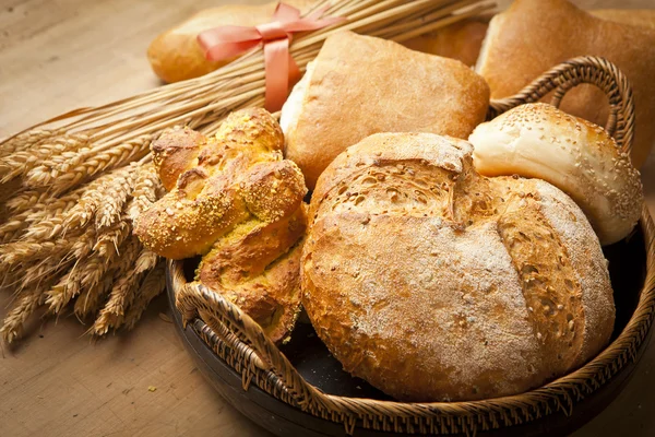 Surtido de pan recién horneado en mesa de madera — Foto de Stock