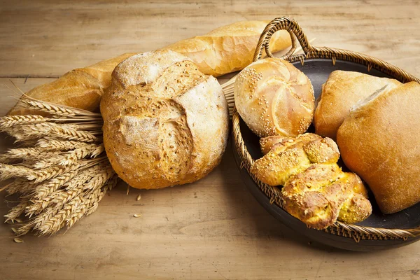 Assortment of fresh baked bread on wood table — Stock Photo, Image