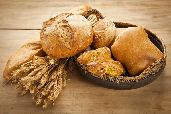 Assortment of fresh baked bread on wood table — Stock Photo, Image