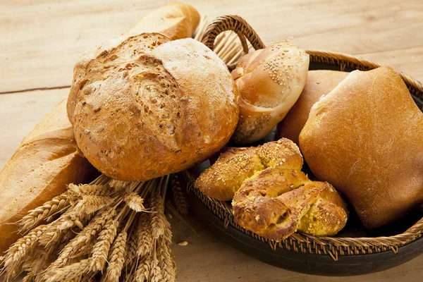 Assortment of fresh baked bread on wood table — Stock Photo, Image