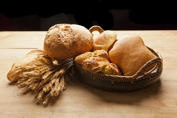 Assortiment van vers gebakken brood op houten tafel — Stockfoto