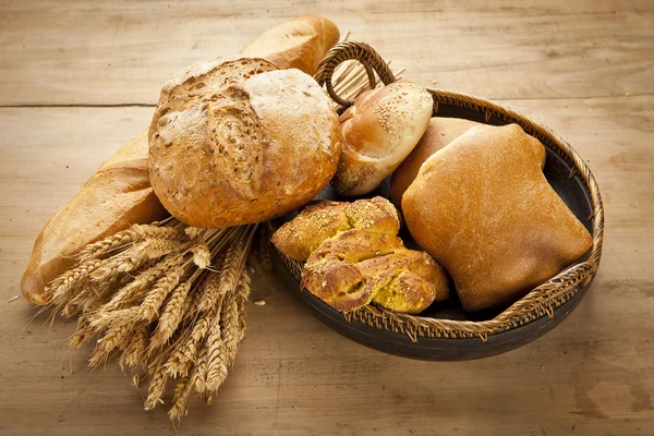 Sortimento de pão fresco assado na mesa de madeira — Fotografia de Stock