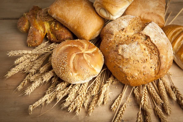 Sortimento de pão fresco assado na mesa de madeira — Fotografia de Stock