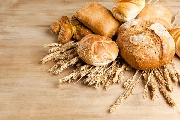 Assortiment van vers gebakken brood op houten tafel — Stockfoto