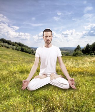 Genç adam dışarıda yoga yapıyor, lotus iksiri.