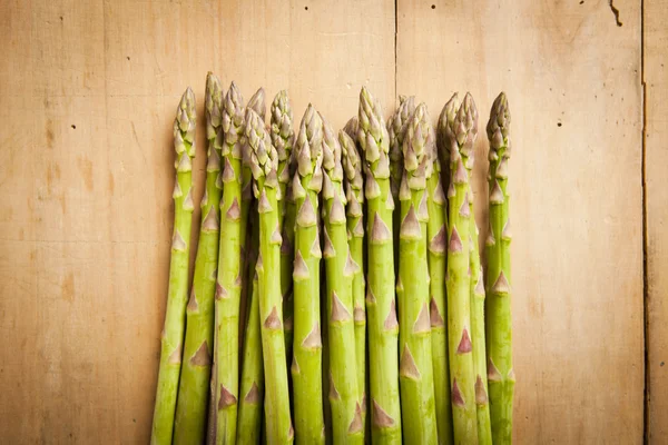 Bunch of fresh green asparagus on wooden background — Stock Photo, Image