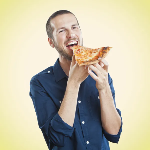 Retrato de um jovem belo homem comendo uma fatia de pizza margherita — Fotografia de Stock