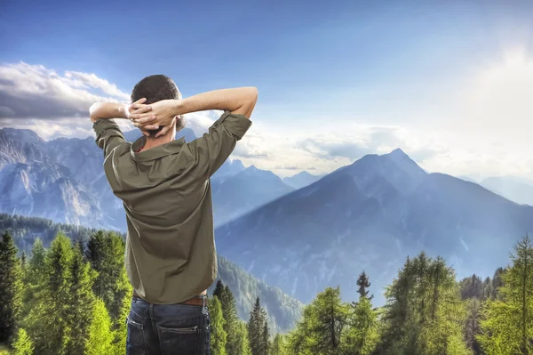 Jeune homme au sommet de la montagne, réalxing et profiter de la vue — Photo