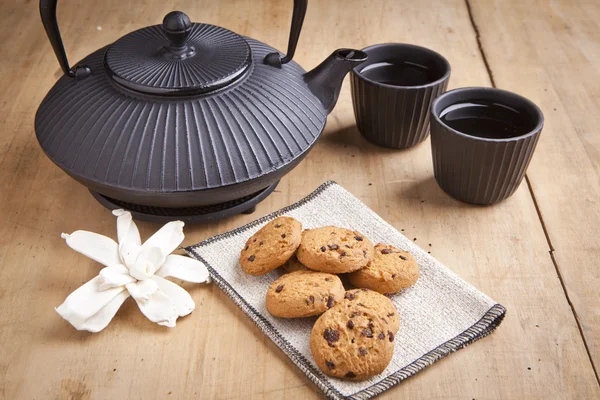 Mooie theepot met chocolade koekjes op houten tafel, heerlijk ontbijt — Stockfoto