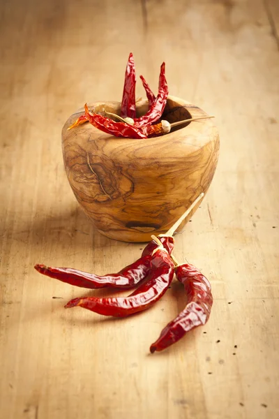 Red hot dry chili peppers over wooden background — Stock Photo, Image