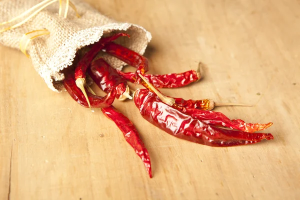 Red hot dry chili peppers over wooden background — Stock Photo, Image