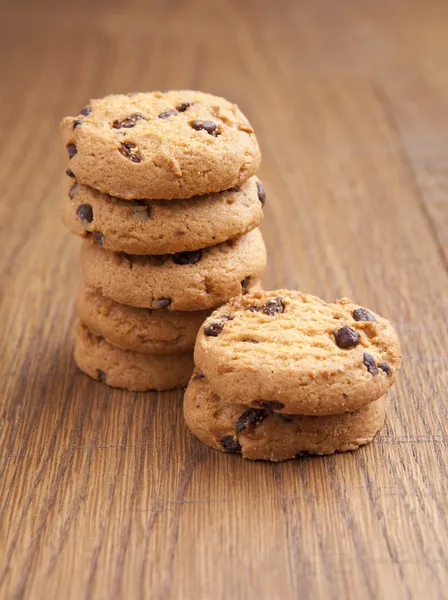 Stack of chocolate biscuits with chocolate on wooden table — Stock Photo, Image