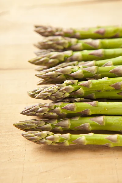 Bunch of fresh green asparagus on wooden background — Stock Photo, Image