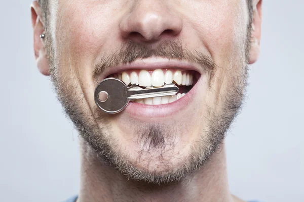 Homem com uma chave nos dentes — Fotografia de Stock