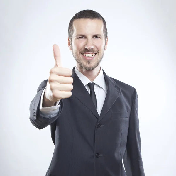 Smiling young businessman with thumb up — Stock Photo, Image