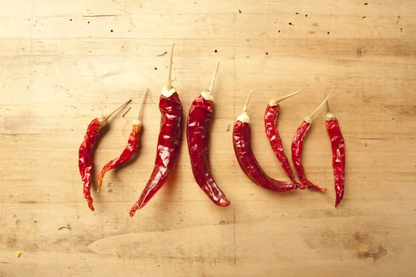 Red hot dry chili peppers over wooden background — Stock Photo, Image