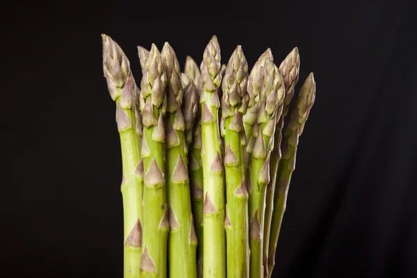 Bunch of fresh green asparagus on black background — Stock Photo, Image