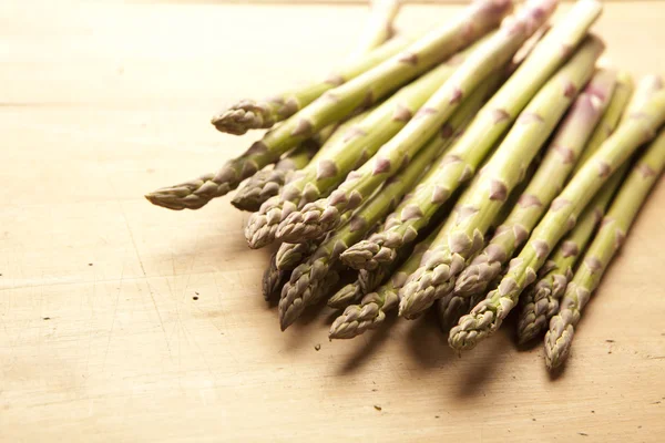 Bunch of fresh green asparagus on wooden background — Stock Photo, Image