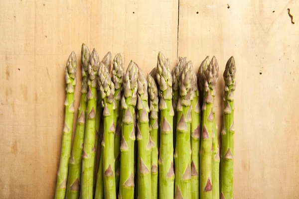 Bunch of fresh green asparagus on wooden background — Stock Photo, Image