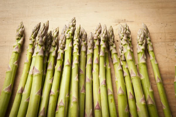 Bunch of fresh green asparagus on wooden background — Stock Photo, Image