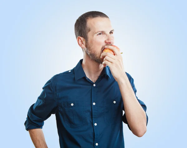 Glada vackra man äta äpple, isolerade över vit bakgrund — Stockfoto